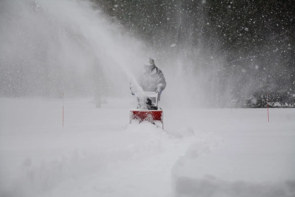 Snowblower clearing a sidewalk during a storm in Edmonton