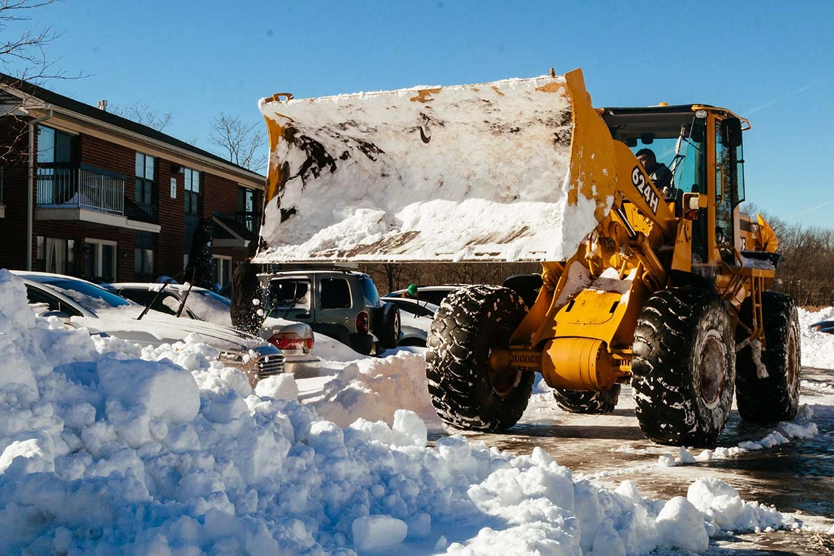 Snow removal vehicle removing piled snow in Edmonton