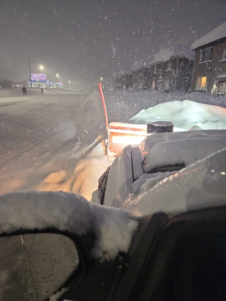 Snow plow working during a blizzard at night in Edmonton
