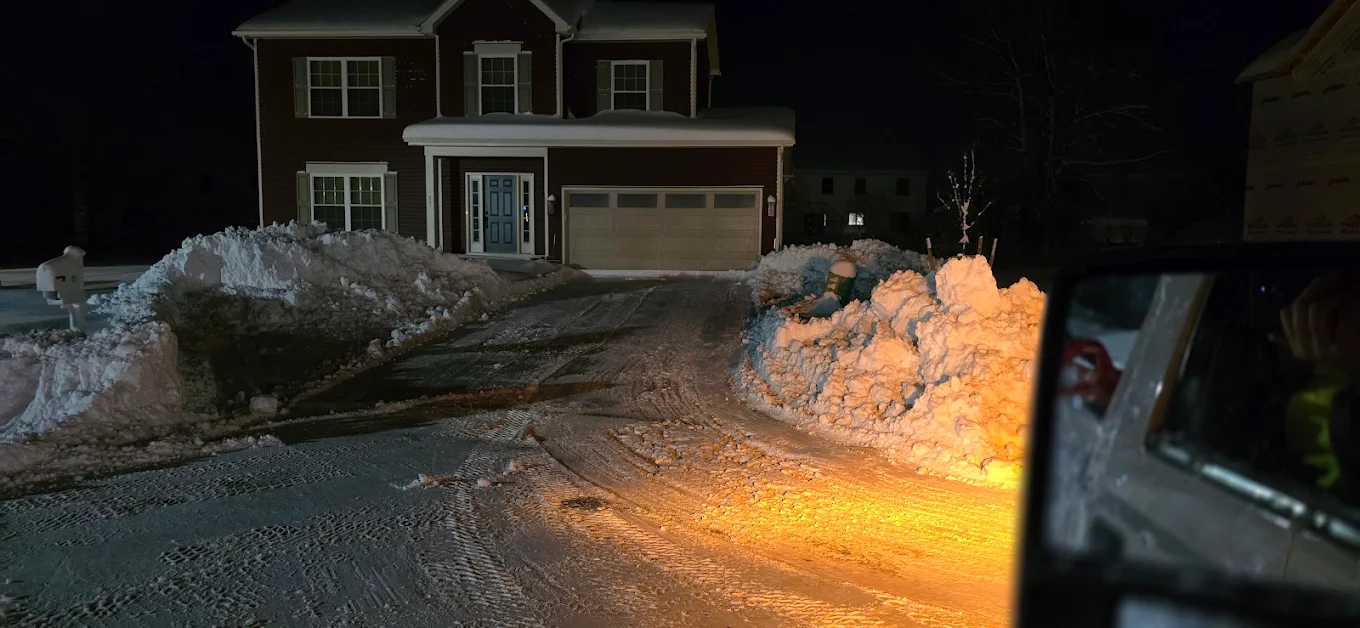 Night driveway snow removal in Edmonton during a winter storm